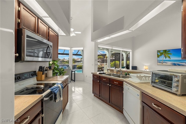 3925 Oasis Blvd, Cape Coral, FL 33914 - kitchen featuring stainless steel microwave, range with electric stovetop, white dishwasher, light countertops, and light tile patterned flooring