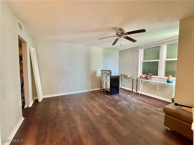 7390 Estero Blvd Unit 702, Fort Myers Beach, FL 33931 - living area with dark wood-style floors, ceiling fan, and a wood stove