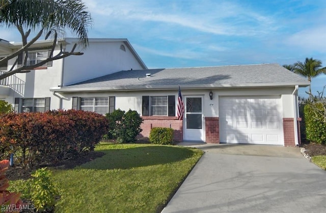 8780 Lueck Ln Unit 4, Fort Myers, FL 33919 - view of front facade featuring an attached garage, a front lawn, brick siding, and driveway