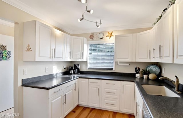 8780 Lueck Ln Unit 4, Fort Myers, FL 33919 - kitchen with a sink, dark countertops, white cabinets, and ornamental molding
