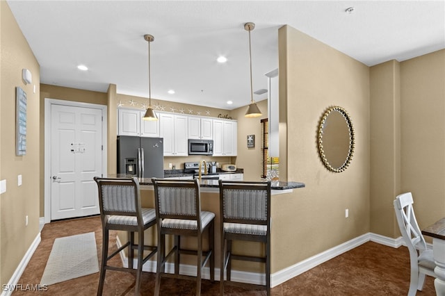 9114 Chula Vista Ln Unit 11901, Naples, FL 34113 - kitchen featuring appliances with stainless steel finishes, dark countertops, a peninsula, decorative light fixtures, and a breakfast bar area