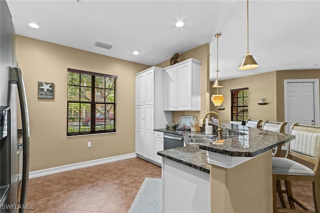 9114 Chula Vista Ln Unit 11901, Naples, FL 34113 - kitchen featuring a peninsula, a kitchen bar, stainless steel dishwasher, white cabinets, and plenty of natural light