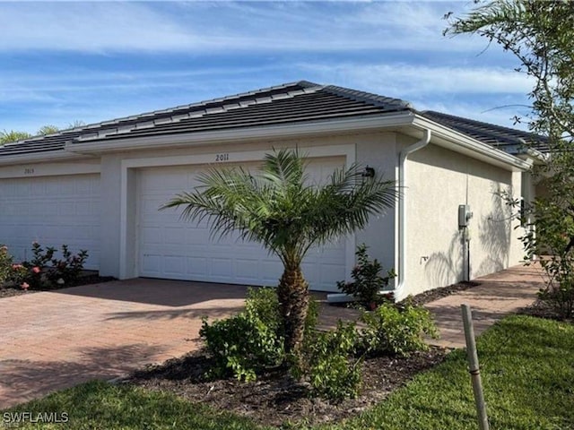 2011 Vermont Ln, Naples, FL 34120 - view of side of property featuring stucco siding and decorative driveway
