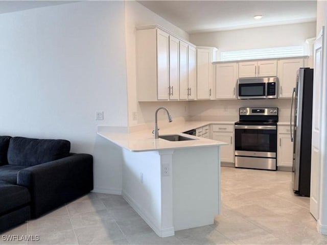 2011 Vermont Ln, Naples, FL 34120 - kitchen featuring stainless steel appliances, open floor plan, a sink, a peninsula, and light countertops