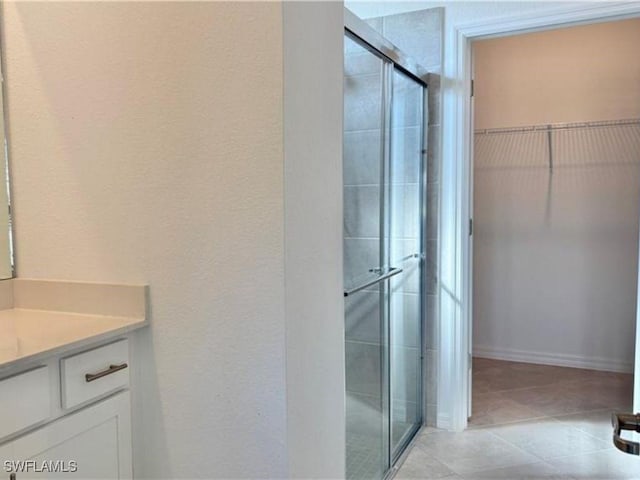 2011 Vermont Ln, Naples, FL 34120 - bathroom with a shower stall, vanity, a walk in closet, and tile patterned flooring