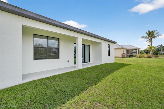 2008 NW 24th Pl, Cape Coral, FL 33993 - back of house featuring stucco siding and a yard
