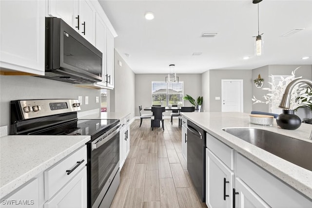 2008 NW 24th Pl, Cape Coral, FL 33993 - kitchen featuring stainless steel appliances, pendant lighting, white cabinetry, light wood finished floors, and recessed lighting