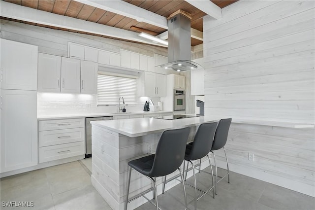 370 Bayland Rd, Fort Myers Beach, FL 33931 - kitchen with a wooden ceiling with exposed beams, stainless steel appliances, island range hood, wooden walls, and white cabinetry