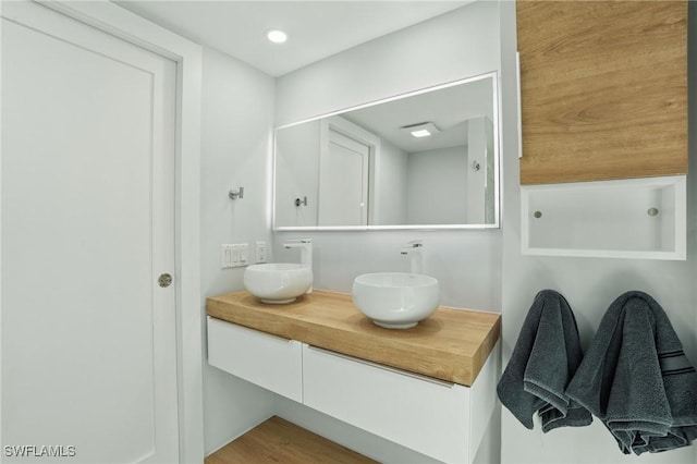 370 Bayland Rd, Fort Myers Beach, FL 33931 - bathroom featuring double vanity and wood finished floors