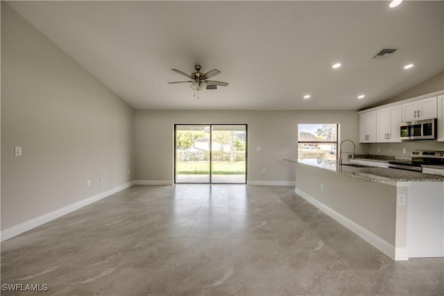 4114 2nd St SW, Lehigh Acres, FL 33976 - kitchen with stainless steel appliances, open floor plan, light stone countertops, recessed lighting, and white cabinetry