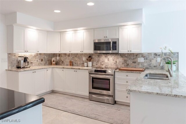3430 27th Ave SW, Naples, FL 34117 - kitchen featuring appliances with stainless steel finishes, a sink, white cabinetry, decorative backsplash, and recessed lighting
