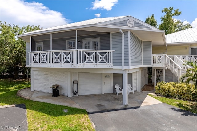 950 Moody Rd Unit 124, North Fort Myers, FL 33903 - view of front facade featuring an attached garage, driveway, metal roof, and stairway