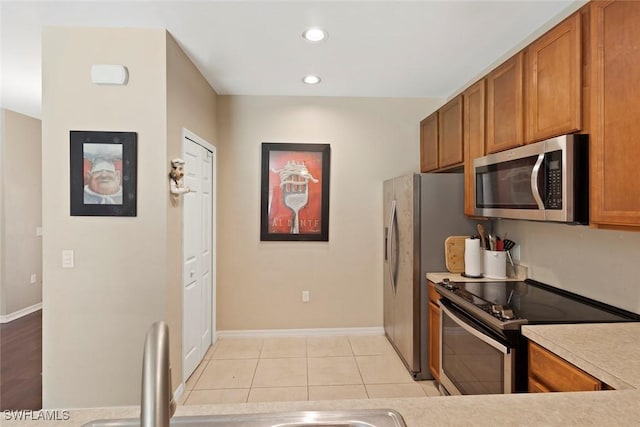 3940 Cherrybrook Loop, Fort Myers, FL 33966 - kitchen with stainless steel microwave, electric range oven, brown cabinetry, light countertops, and recessed lighting