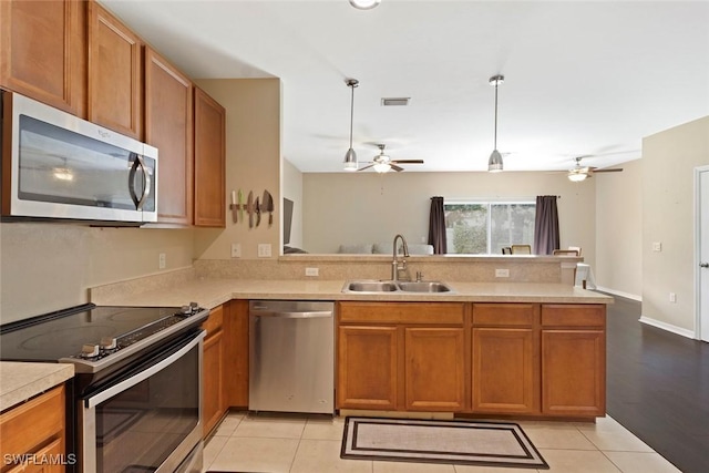 3940 Cherrybrook Loop, Fort Myers, FL 33966 - kitchen featuring appliances with stainless steel finishes, ceiling fan, a peninsula, light countertops, and brown cabinets