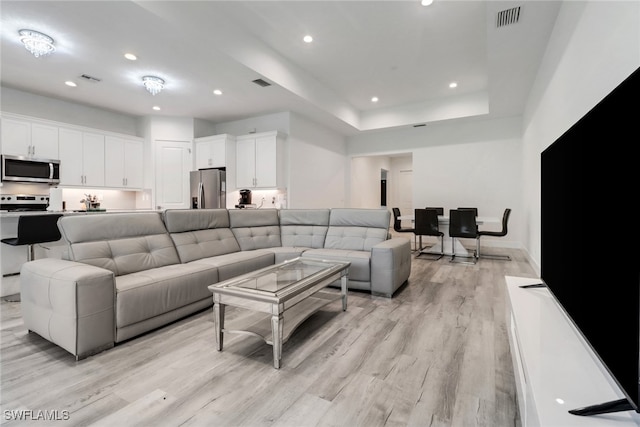 3320 41st Ave NE, Naples, FL 34120 - living room with light wood-type flooring, recessed lighting, and a raised ceiling