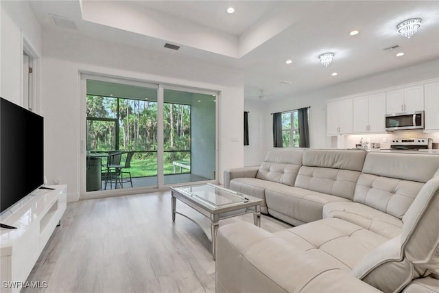 3320 41st Ave NE, Naples, FL 34120 - living room with light wood-style floors, recessed lighting, and a tray ceiling