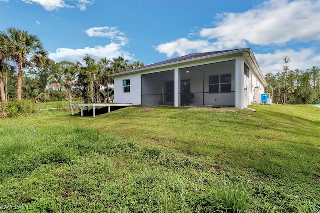 3320 41st Ave NE, Naples, FL 34120 - back of property with a sunroom, a yard, and stucco siding