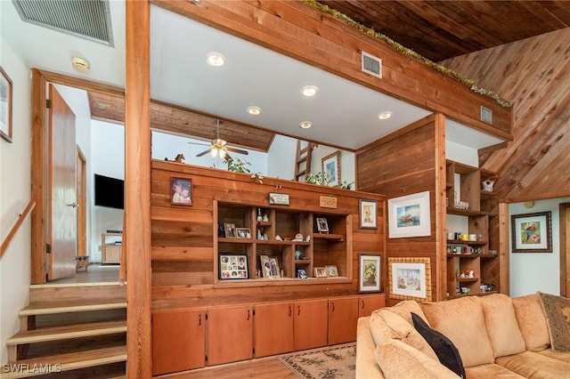 7786 Breakwater Ct, Bokeelia, FL 33922 - living room with a ceiling fan, recessed lighting, wood walls, wood finished floors, and stairs