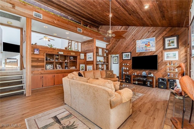 7786 Breakwater Ct, Bokeelia, FL 33922 - living room with ceiling fan, wood walls, light wood-type flooring, wooden ceiling, and stairs