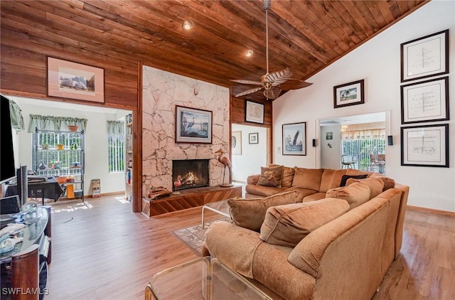 7786 Breakwater Ct, Bokeelia, FL 33922 - living area with wooden ceiling, a fireplace, ceiling fan, light wood-type flooring, and high vaulted ceiling