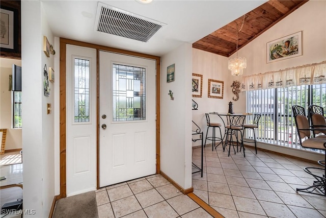 7786 Breakwater Ct, Bokeelia, FL 33922 - foyer entrance with wooden ceiling, light tile patterned floors, a chandelier, and lofted ceiling