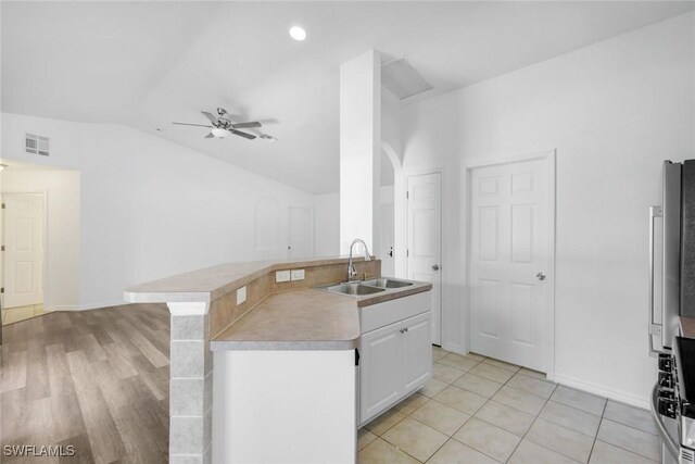 726 SW 12th St, Cape Coral, FL 33991 - kitchen with lofted ceiling, a ceiling fan, white cabinets, range, and fridge