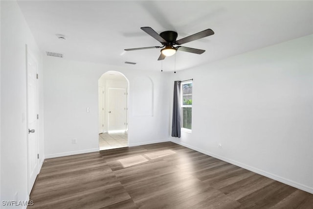 726 SW 12th St, Cape Coral, FL 33991 - empty room featuring arched walkways, a ceiling fan, wood finished floors, and a smoke detector