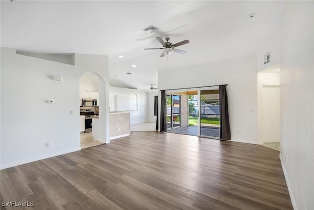 726 SW 12th St, Cape Coral, FL 33991 - unfurnished living room featuring ceiling fan, wood finished floors, arched walkways, and high vaulted ceiling