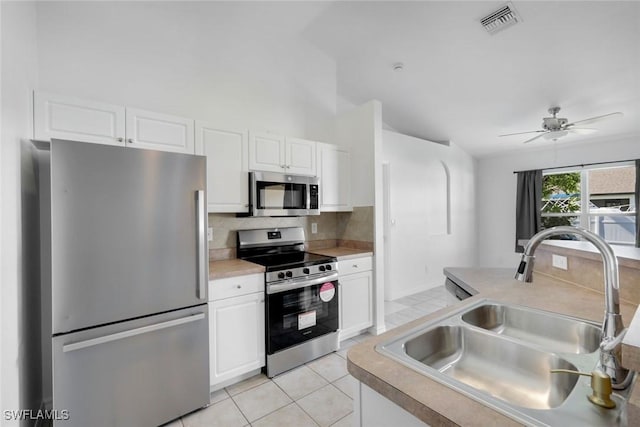 726 SW 12th St, Cape Coral, FL 33991 - kitchen featuring stainless steel appliances, tasteful backsplash, white cabinetry, and light tile patterned flooring