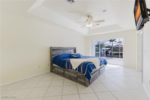 1525 SW 43rd Ter, Cape Coral, FL 33914 - bedroom with a tray ceiling, baseboards, light tile patterned flooring, and a ceiling fan