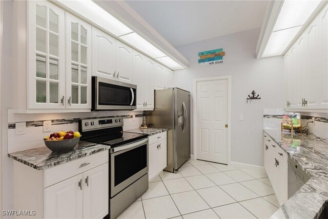 1525 SW 43rd Ter, Cape Coral, FL 33914 - kitchen featuring stainless steel appliances, light stone counters, glass insert cabinets, and white cabinetry
