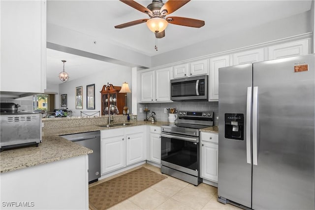 10020 Maddox Ln Unit 113, Bonita Springs, FL 34135 - kitchen with stainless steel appliances, decorative backsplash, white cabinetry, light stone counters, and a ceiling fan
