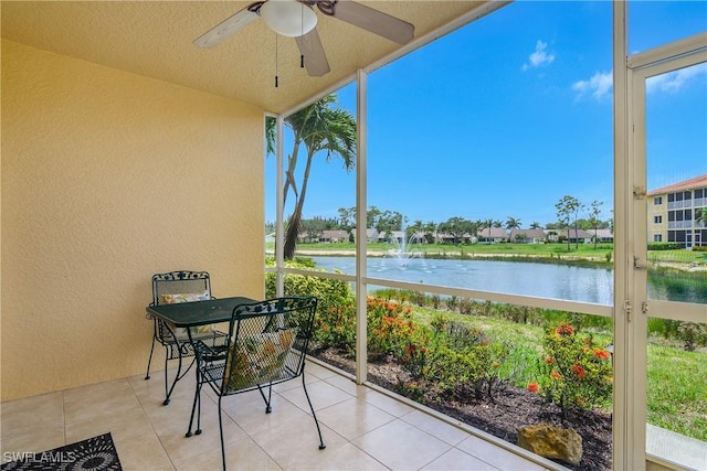 10020 Maddox Ln Unit 113, Bonita Springs, FL 34135 - unfurnished sunroom with a wall of windows, a water view, ceiling fan, a textured wall, and tile patterned floors