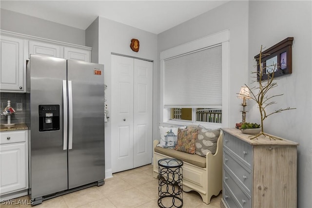 10020 Maddox Ln Unit 113, Bonita Springs, FL 34135 - kitchen featuring stainless steel fridge, white cabinets, light tile patterned flooring, and backsplash