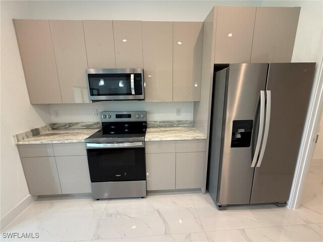 3508 17th St SW, Lehigh Acres, FL 33976 - kitchen featuring appliances with stainless steel finishes, light marble finish floors, gray cabinets, and baseboards