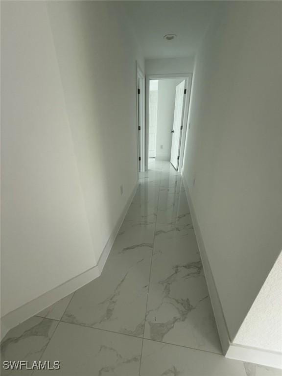 3508 17th St SW, Lehigh Acres, FL 33976 - corridor featuring baseboards and light marble finish flooring