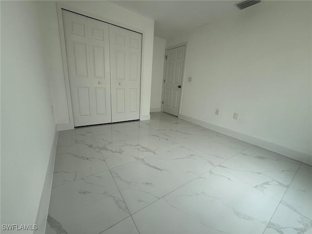 3508 17th St SW, Lehigh Acres, FL 33976 - unfurnished bedroom with light marble finish flooring, baseboards, and a closet