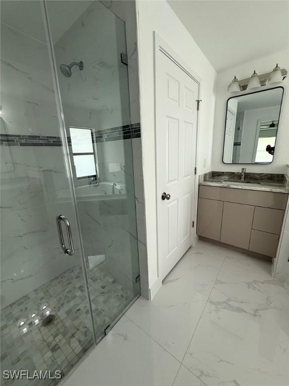 3508 17th St SW, Lehigh Acres, FL 33976 - full bathroom featuring marble look tile flooring, vanity, and a marble finish shower