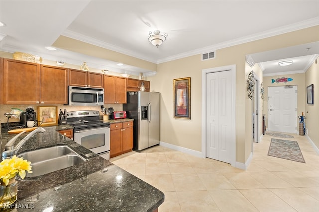 28750 Trails Edge Blvd Unit 303, Bonita Springs, FL 34134 - kitchen with appliances with stainless steel finishes, ornamental molding, light tile patterned floors, tasteful backsplash, and brown cabinetry