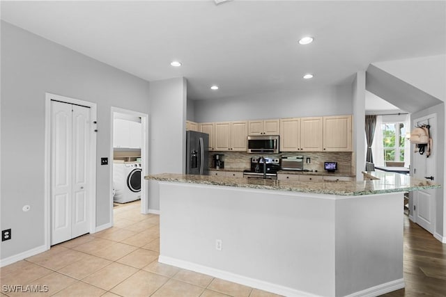 21314 Braxfield Loop, Estero, FL 33928 - kitchen with stainless steel appliances, washer / clothes dryer, decorative backsplash, light stone counters, and light brown cabinets