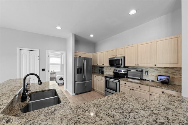 21314 Braxfield Loop, Estero, FL 33928 - kitchen featuring appliances with stainless steel finishes, a sink, light brown cabinetry, decorative backsplash, and light tile patterned flooring
