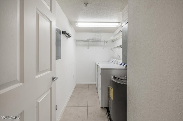 8244 Key Royal Cir Unit 615, Naples, FL 34119 - laundry area featuring washing machine and dryer, electric panel, light tile patterned flooring, and a textured ceiling