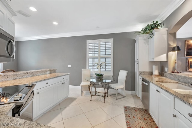 5963 Sand Wedge Ln Unit 203, Naples, FL 34110 - kitchen featuring stainless steel appliances, ornamental molding, white cabinetry, light stone counters, and light tile patterned floors