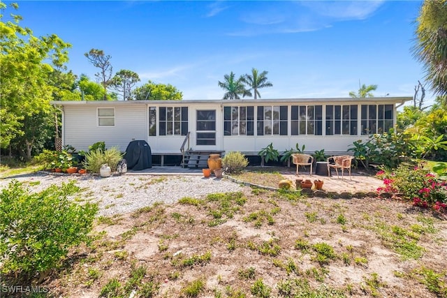 5228 Stringfellow Rd, Saint James City, FL 33956 - back of property featuring a sunroom, entry steps, and a patio area