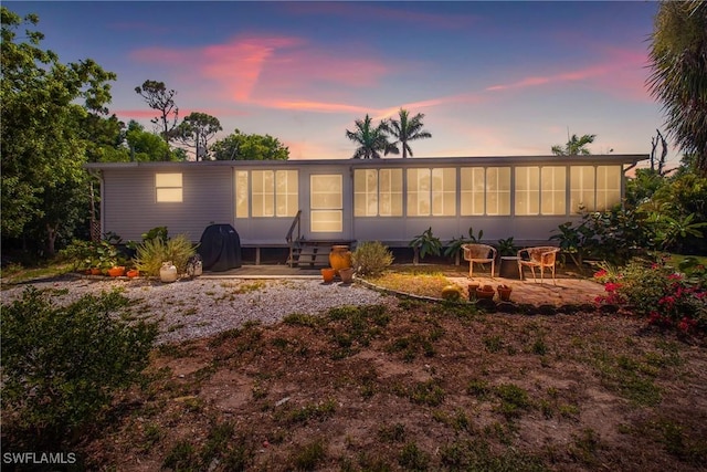 5228 Stringfellow Rd, Saint James City, FL 33956 - rear view of property featuring a sunroom, a patio, and entry steps