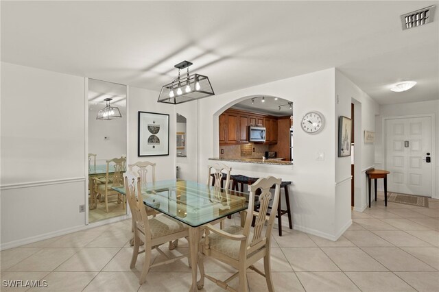 12170 Kelly Sands Way Unit 721, Fort Myers, FL 33908 - dining space with light tile patterned floors, baseboards, and arched walkways