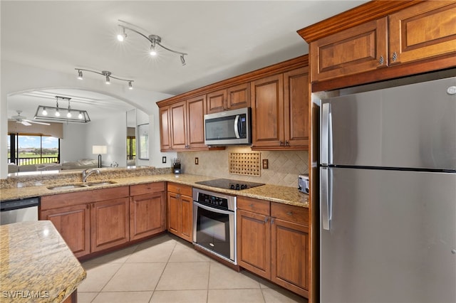 12170 Kelly Sands Way Unit 721, Fort Myers, FL 33908 - kitchen featuring appliances with stainless steel finishes, a sink, brown cabinets, light tile patterned flooring, and backsplash