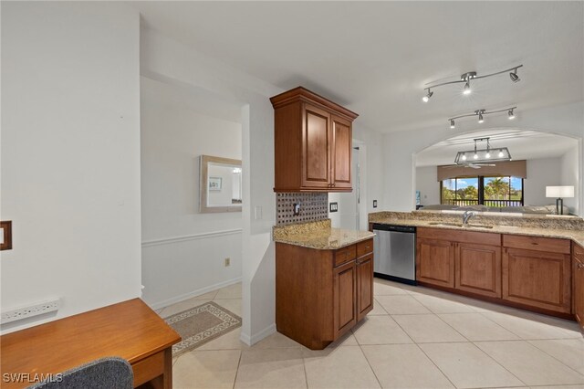 12170 Kelly Sands Way Unit 721, Fort Myers, FL 33908 - kitchen with stainless steel dishwasher, a sink, arched walkways, light tile patterned floors, and brown cabinets