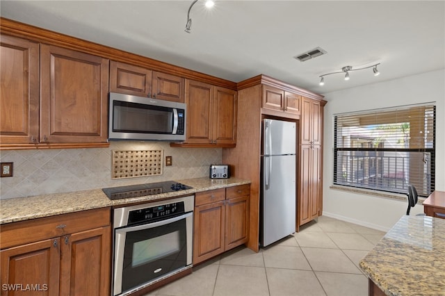12170 Kelly Sands Way Unit 721, Fort Myers, FL 33908 - kitchen featuring stainless steel appliances, brown cabinetry, backsplash, and light tile patterned floors