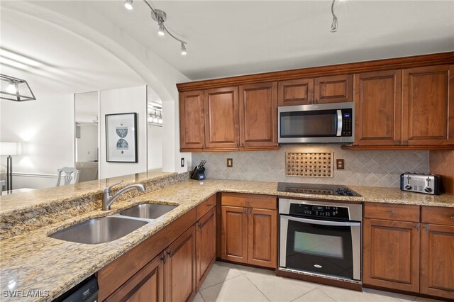 12170 Kelly Sands Way Unit 721, Fort Myers, FL 33908 - kitchen featuring appliances with stainless steel finishes, a sink, light stone countertops, and decorative backsplash